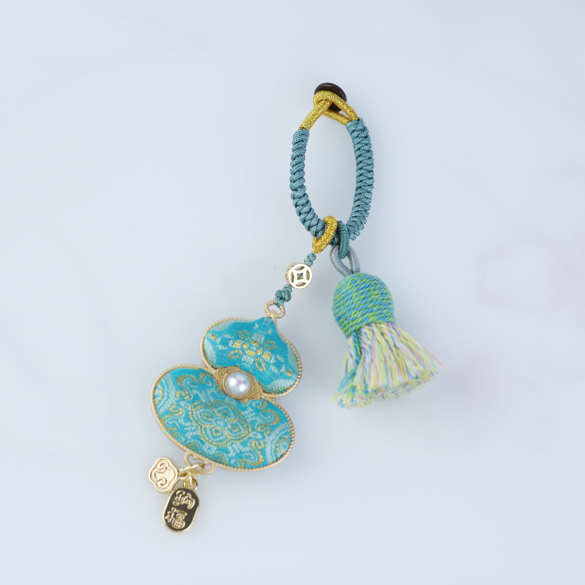 Handmade Blue Gourd Lucky Charm crafted from Song brocade fabric with gold details and tassel, symbolizing peace and prosperity.